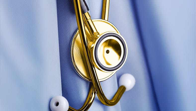 Goldenes Stethoskop hängt an hellblauem Arztkittel